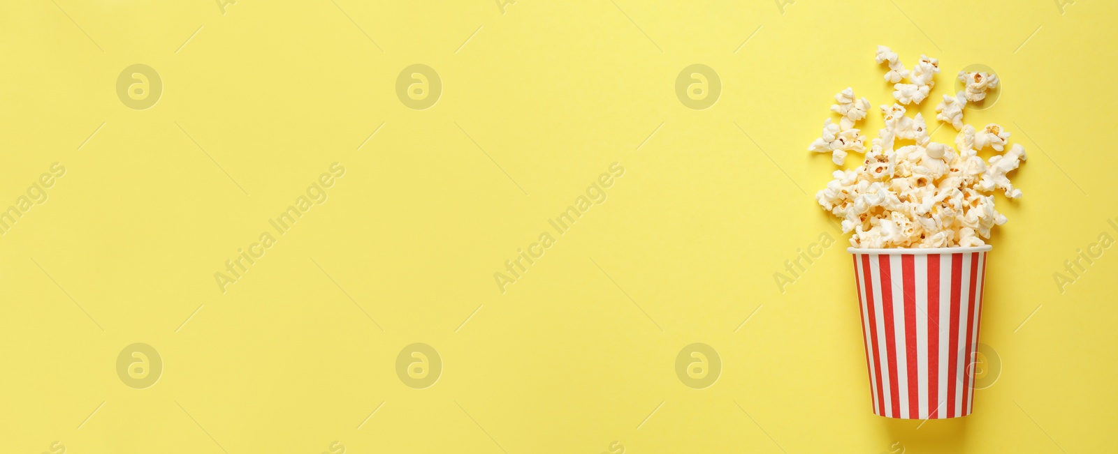Image of Delicious popcorn and space for text on yellow background, top view. Banner design