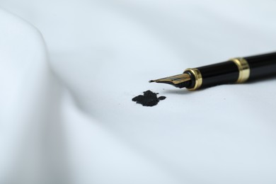 Photo of Pen and stain of black ink on white shirt, closeup. Space for text