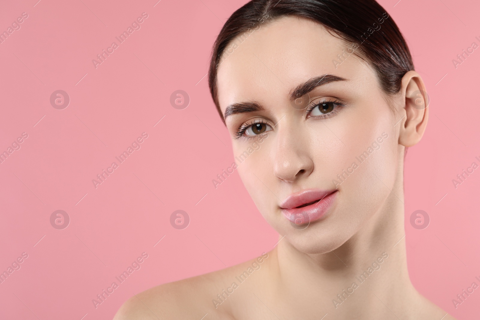 Photo of Portrait of beautiful young woman on pink background. Space for text