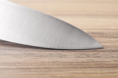 Photo of Sharp knife on wooden background, closeup of blade