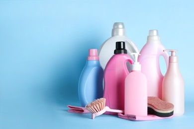 Photo of Different cleaning supplies and tools on light blue background, space for text