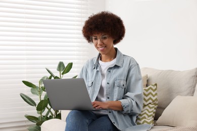 Photo of Beautiful young woman using laptop in room