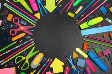 Flat lay composition with different school stationery on chalkboard surface