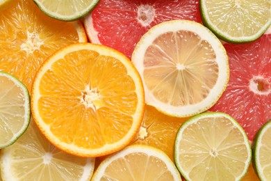 Photo of Different sliced citrus fruits as background, top view