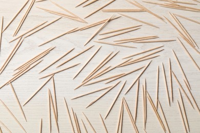 Photo of Disposable toothpicks on white wooden background, flat lay