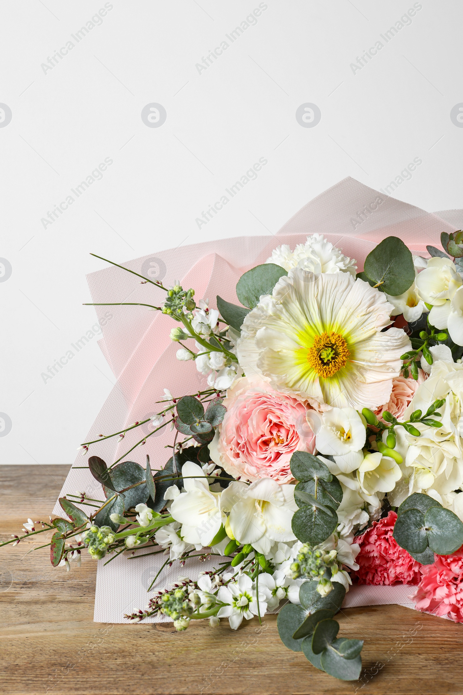 Photo of Bouquet of beautiful flowers on wooden table, closeup