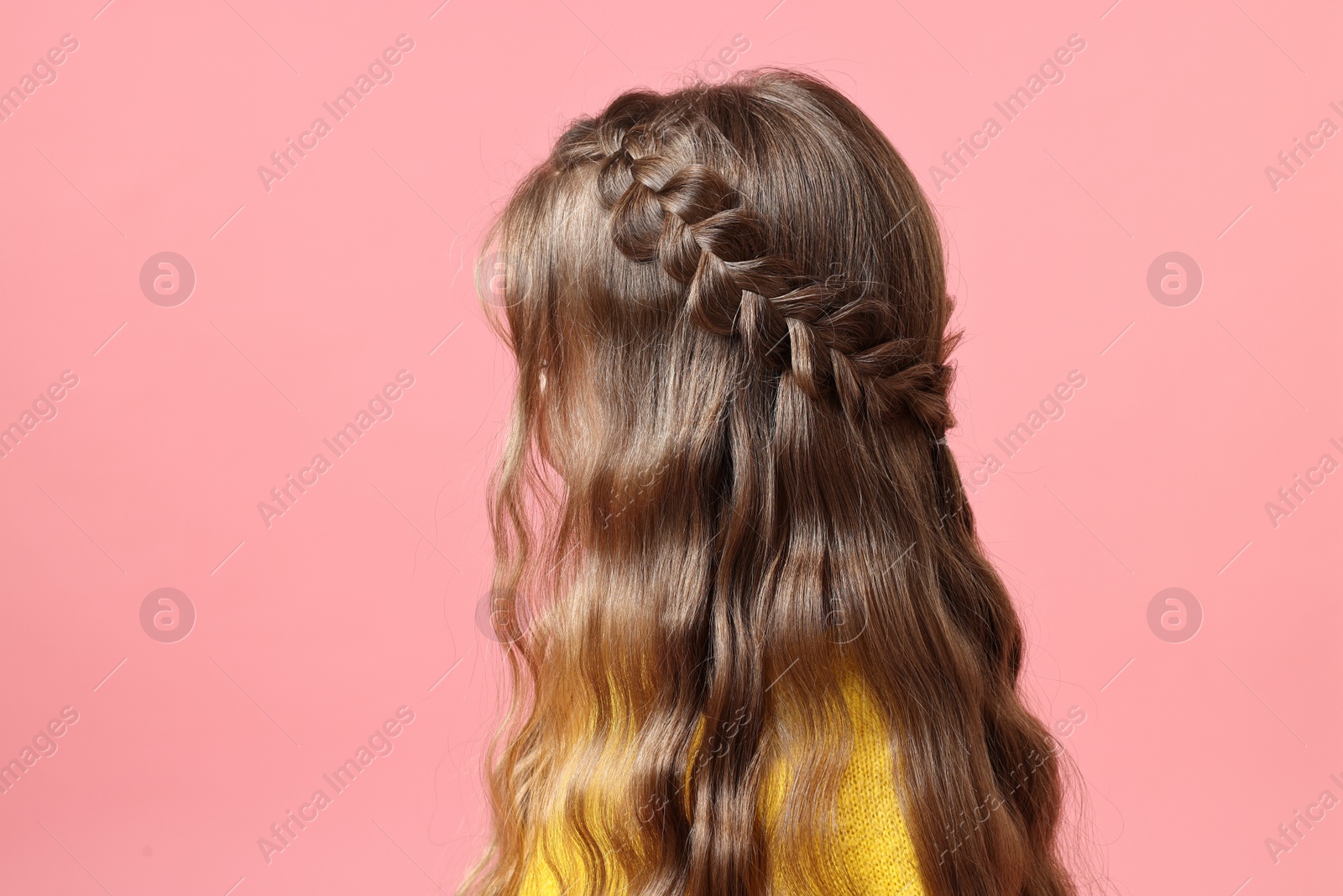 Photo of Little girl with braided hair on pink background