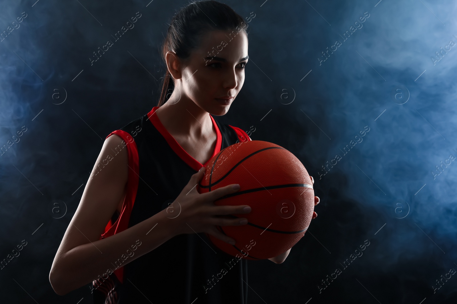 Photo of Basketball player with ball on black background