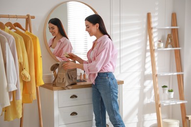 Young woman packing backpack for work day at home. Morning routine