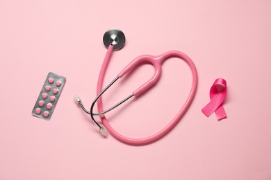 Pink ribbon, stethoscope and pills on color background, flat lay. Breast cancer awareness