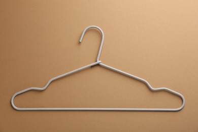 Photo of Empty hanger on brown background, top view