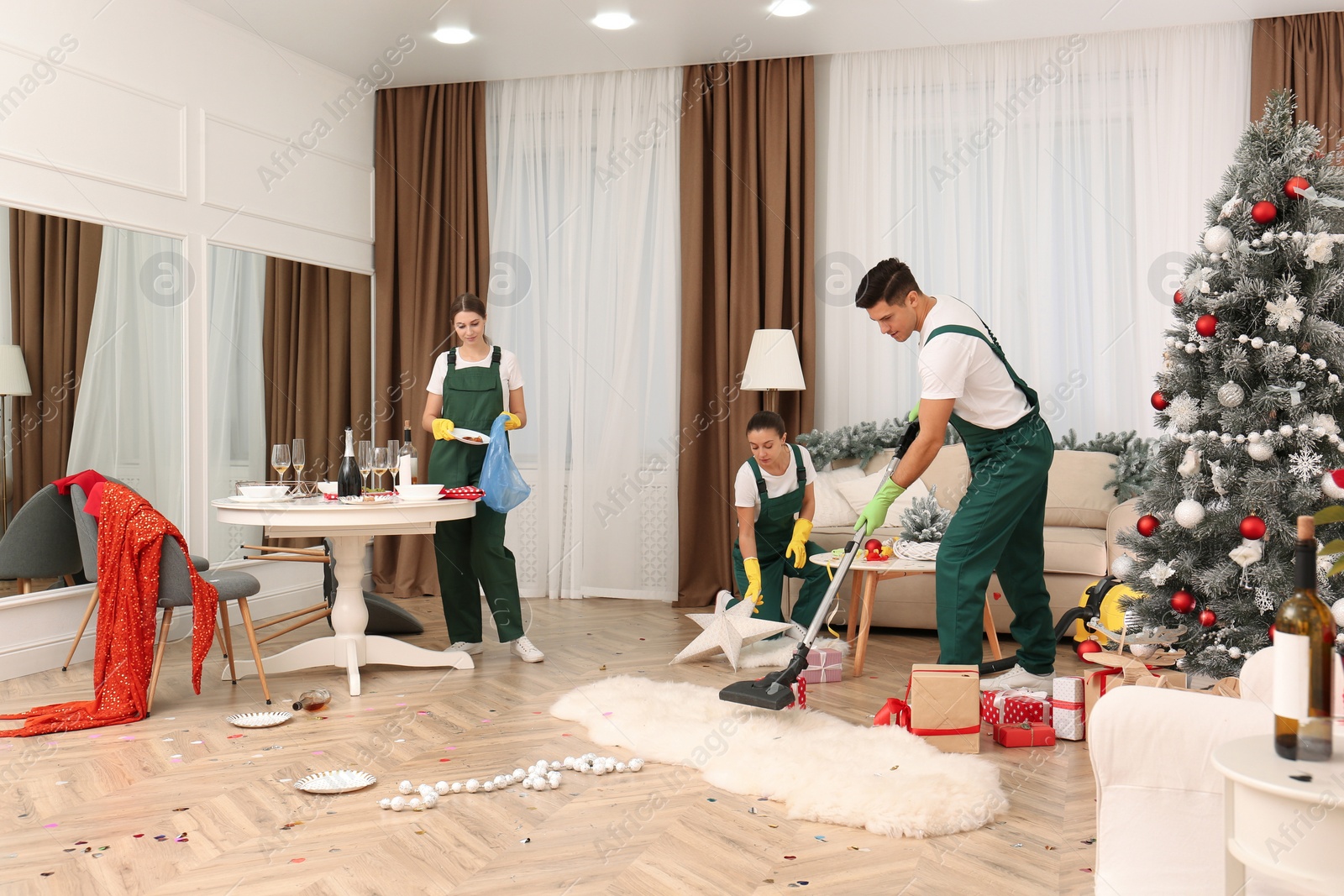 Photo of Cleaning service team working in messy room after New Year party