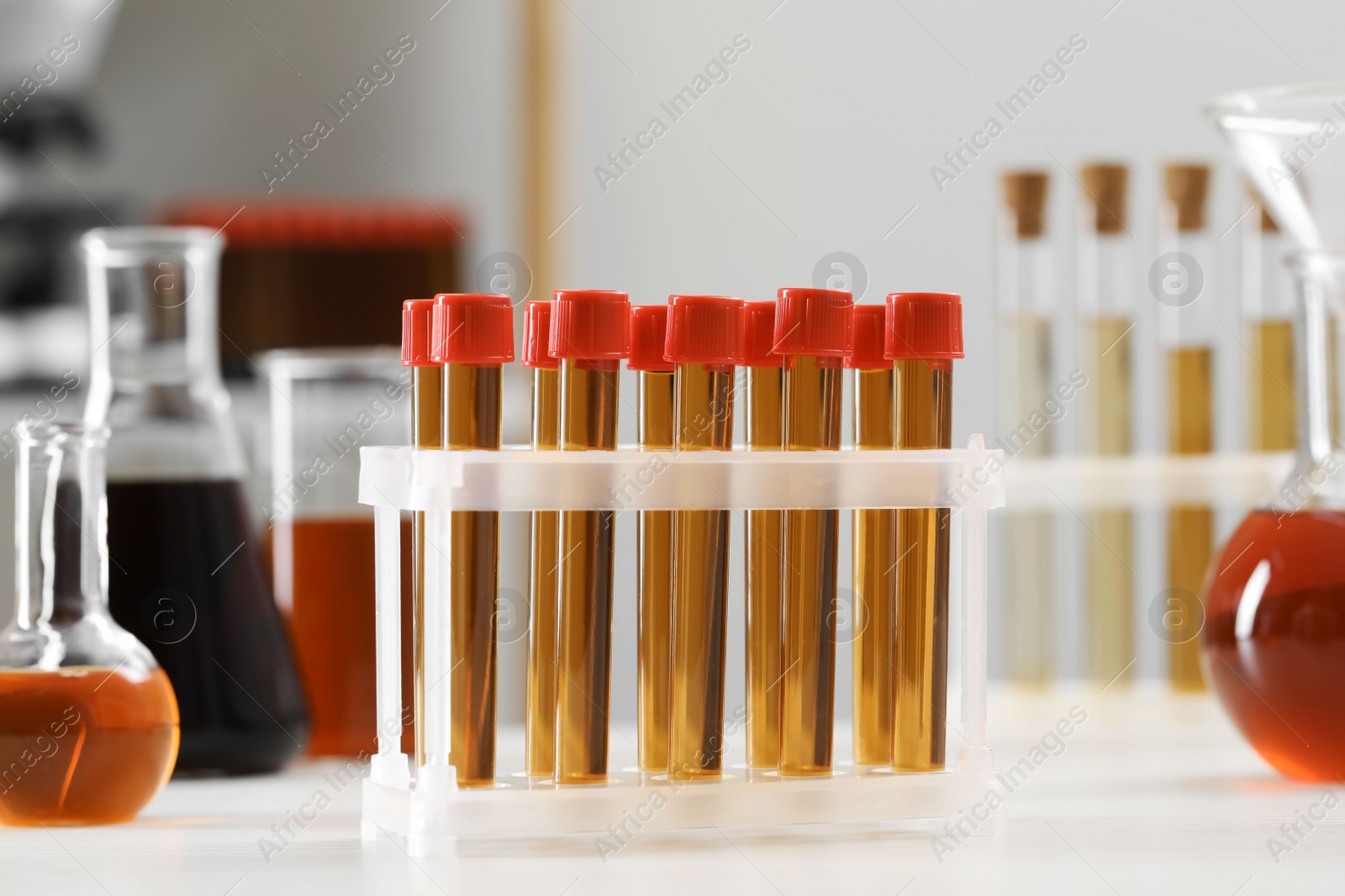 Photo of Test tubes with brown liquid on white table