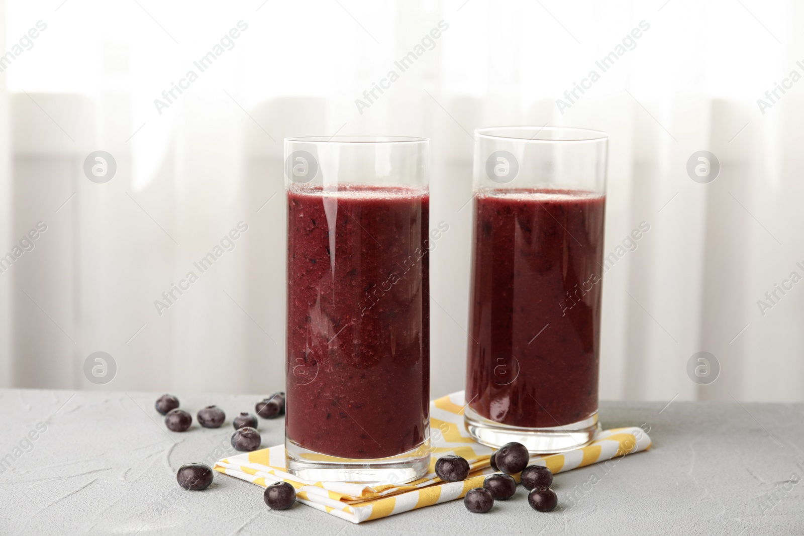 Photo of Glasses with delicious acai smoothie on table