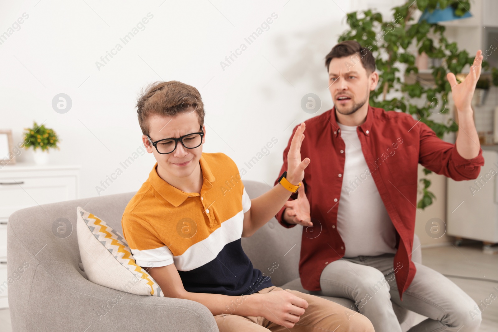 Photo of Father scolding his teenager son at home