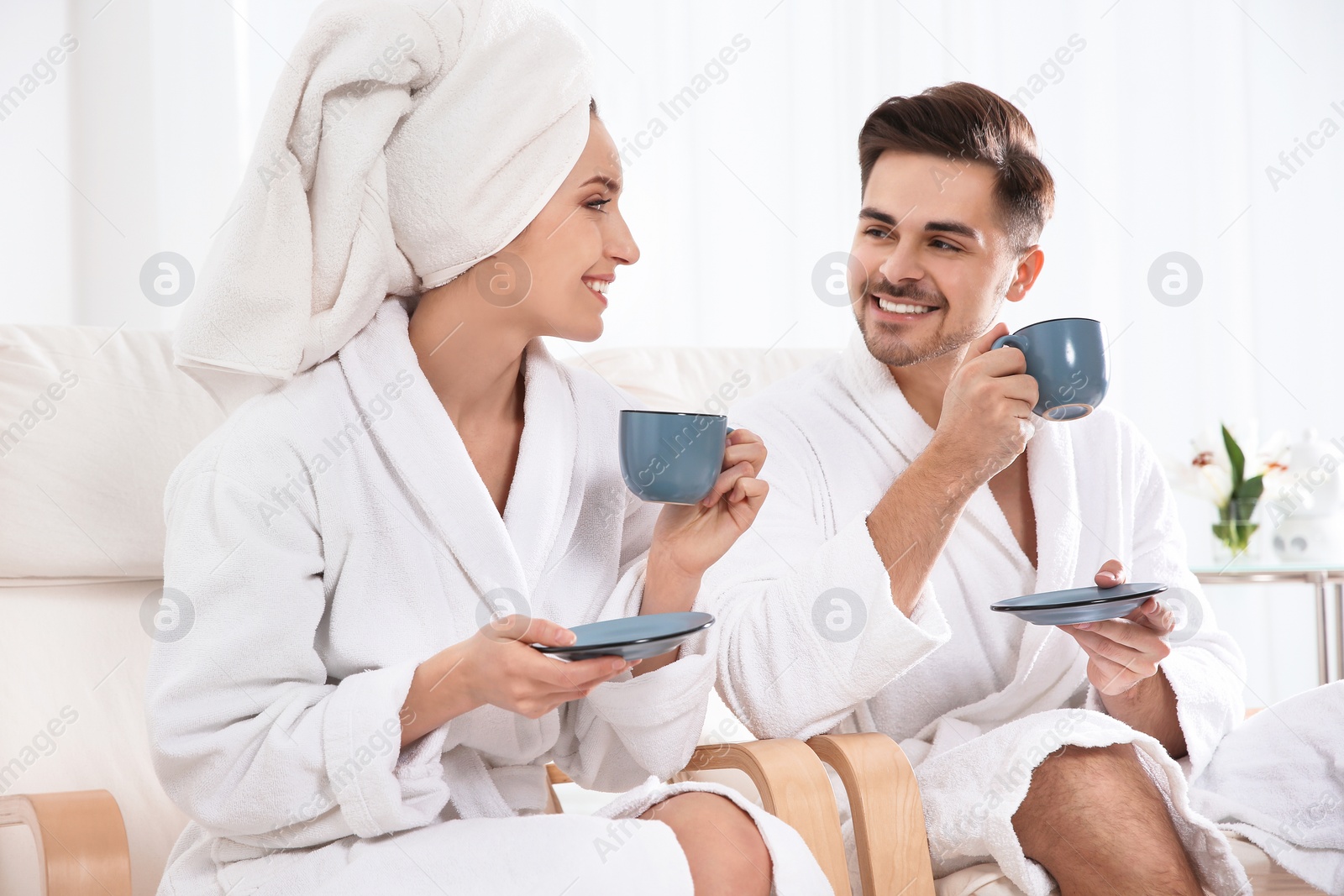 Photo of Romantic young couple with tea in spa salon