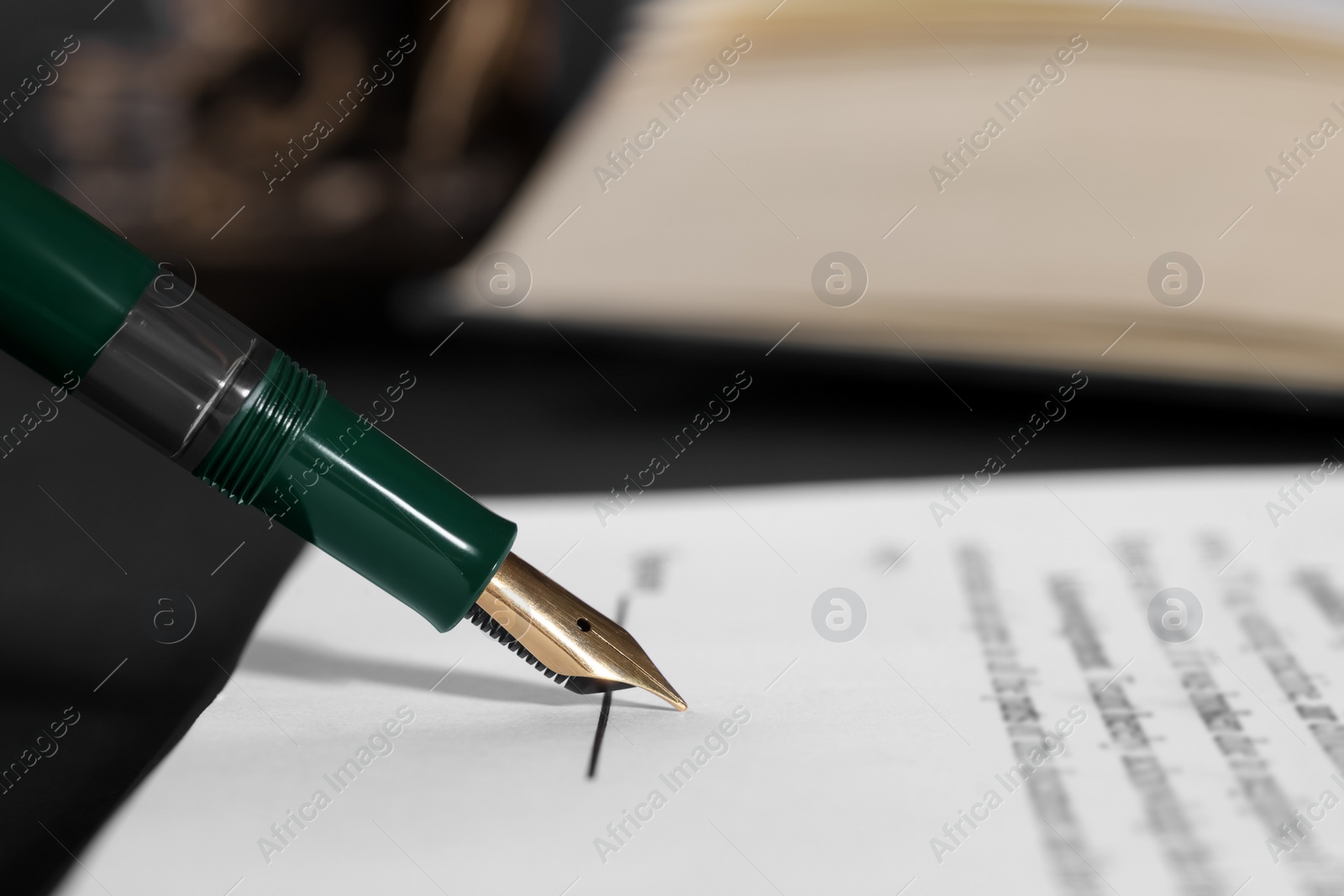 Photo of Signing document with fountain pen at table, closeup and space for text. Notary contract