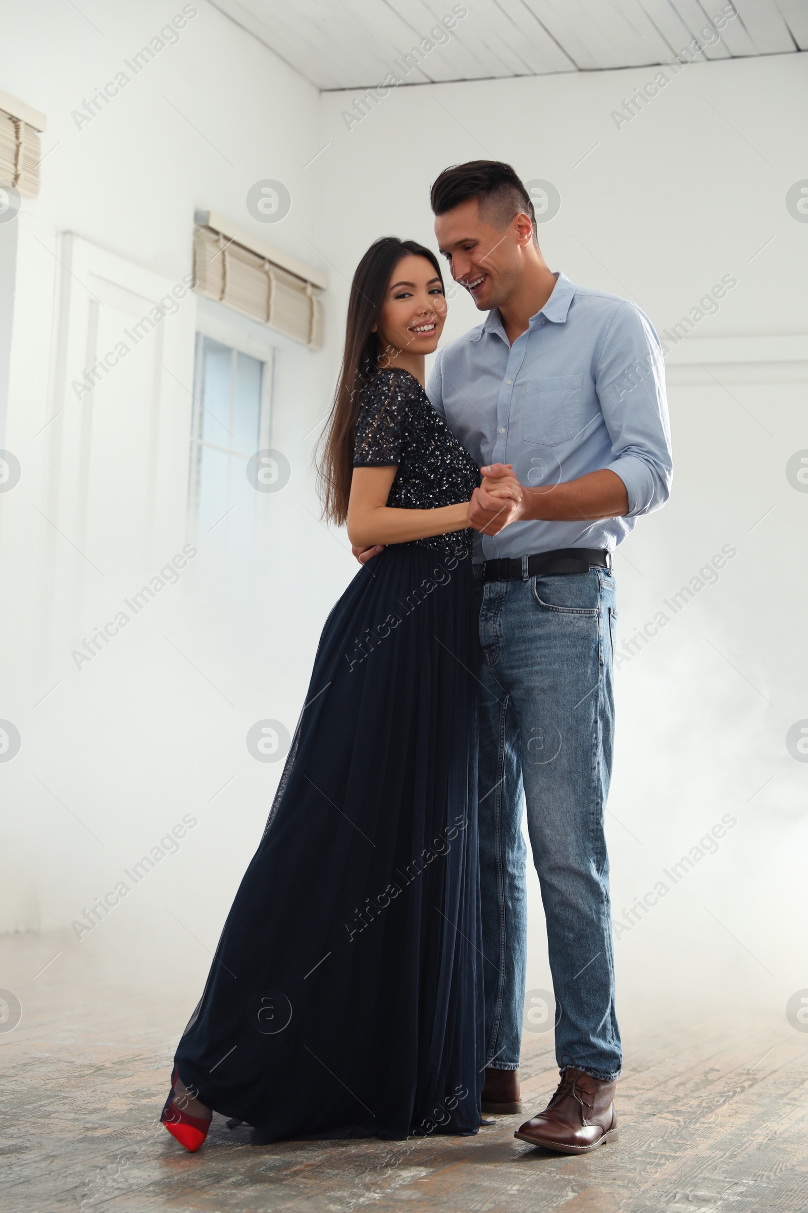 Photo of Lovely young couple dancing together in ballroom