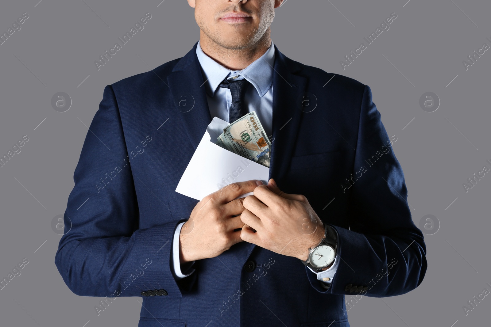 Photo of Man putting bribe into pocket on grey background, closeup