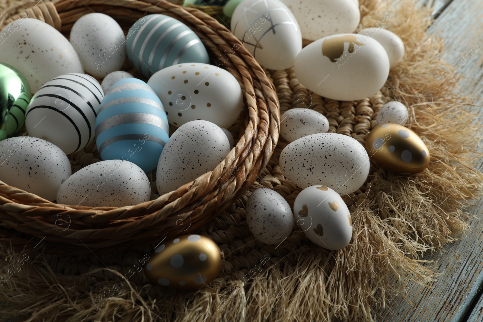 Photo of Decorative nest and many beautiful Easter eggs on table