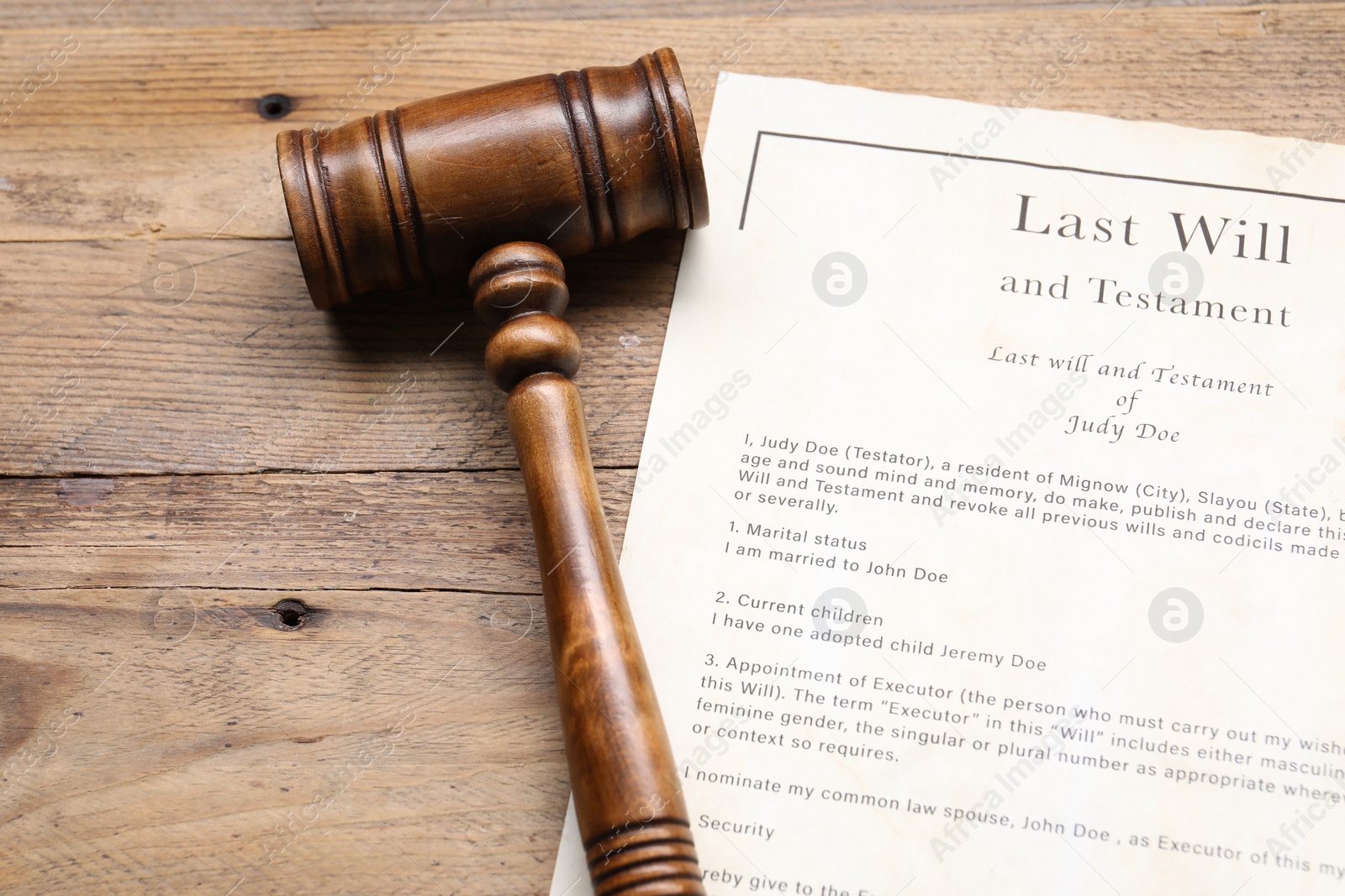 Photo of Last Will and Testament with gavel on wooden table, above view