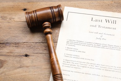 Photo of Last Will and Testament with gavel on wooden table, above view