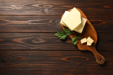 Photo of Tasty butter and parsley on wooden table, top view. Space for text