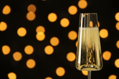 Photo of Glass of champagne against blurred lights. Space for text