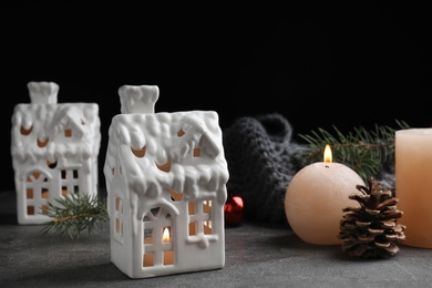 Photo of Composition with candles in house shaped holders on grey table. Christmas decoration
