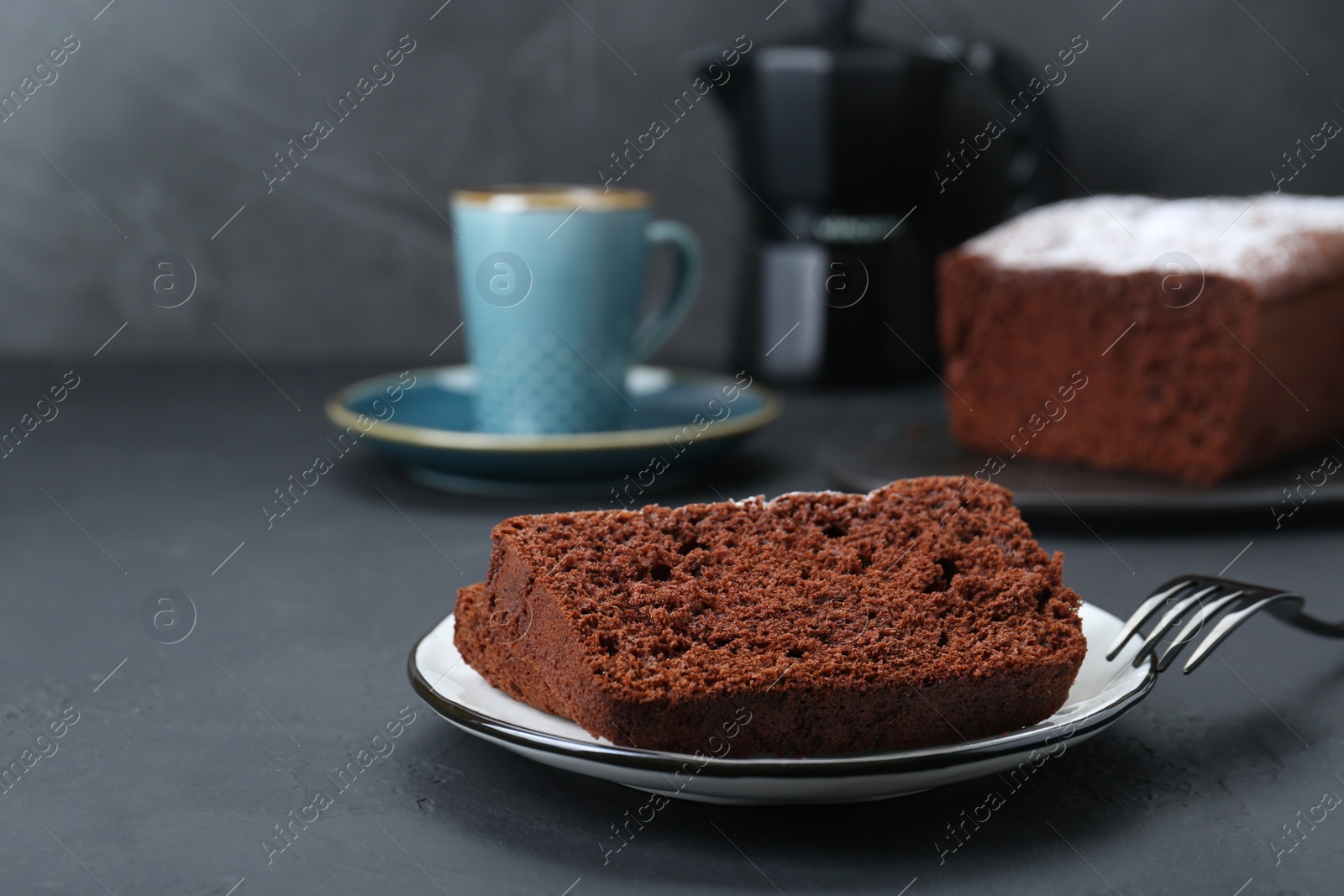 Photo of Pieces of tasty chocolate sponge cake on black table