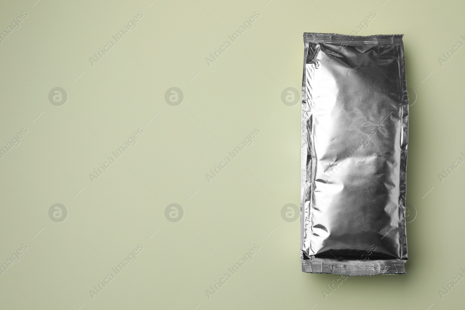 Photo of Blank foil package on light background, top view. Space for text