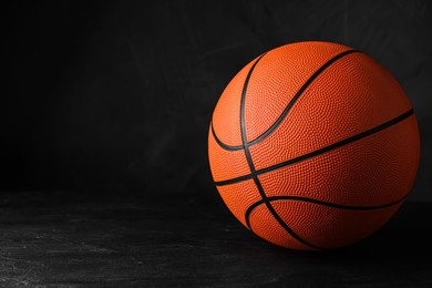 Photo of Orange ball on black background, space for text. Basketball equipment