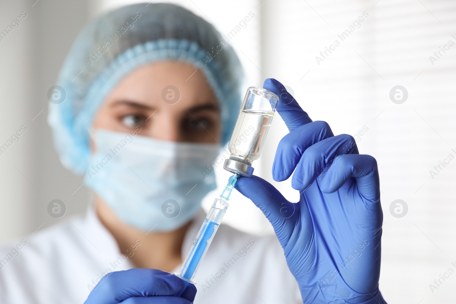 Photo of Doctor filling syringe with medication in clinic, focus on hands. Vaccination and immunization