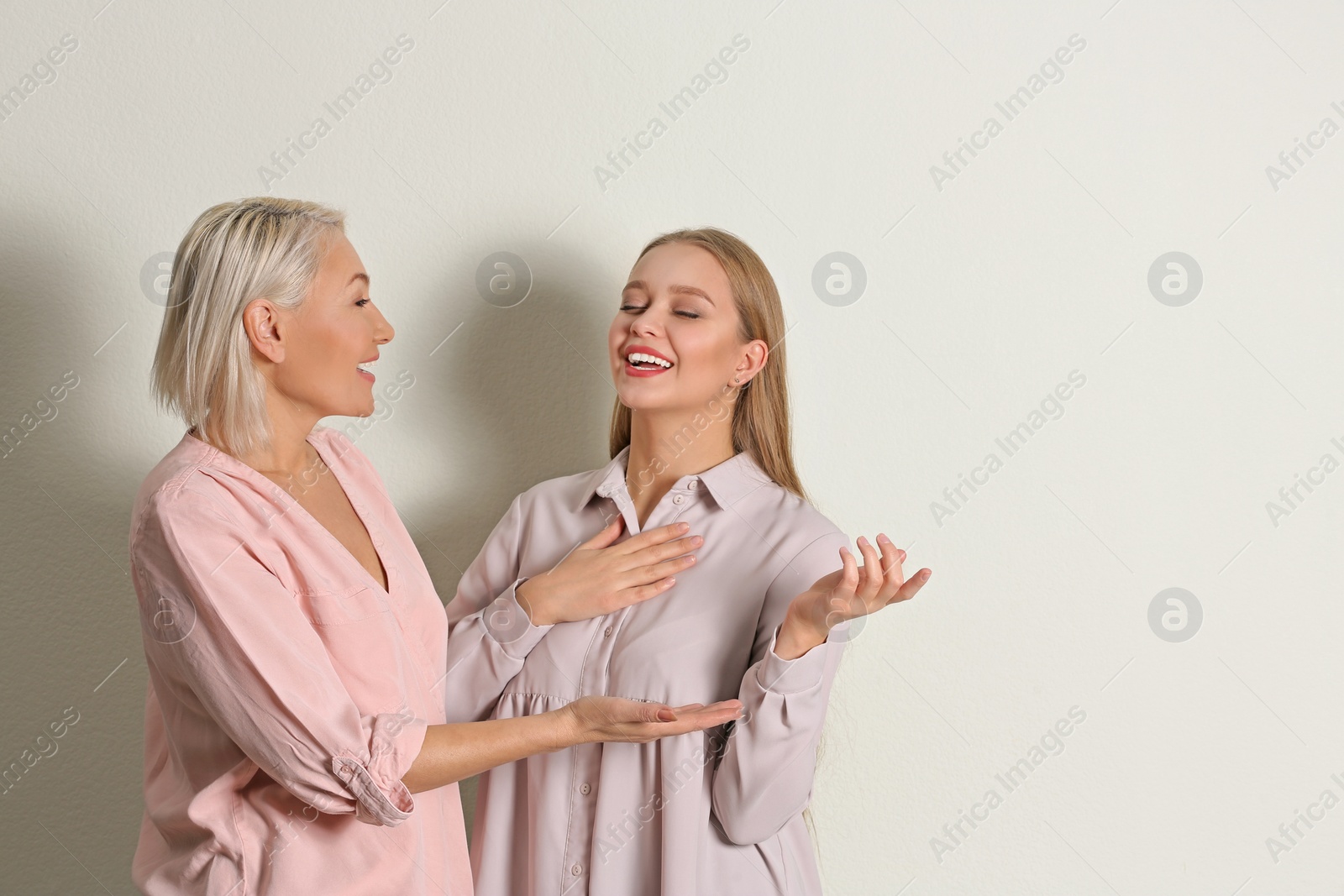 Photo of Mother and her adult daughter on white background