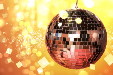 Image of Shiny disco ball under golden lights, space for text. Bokeh effect