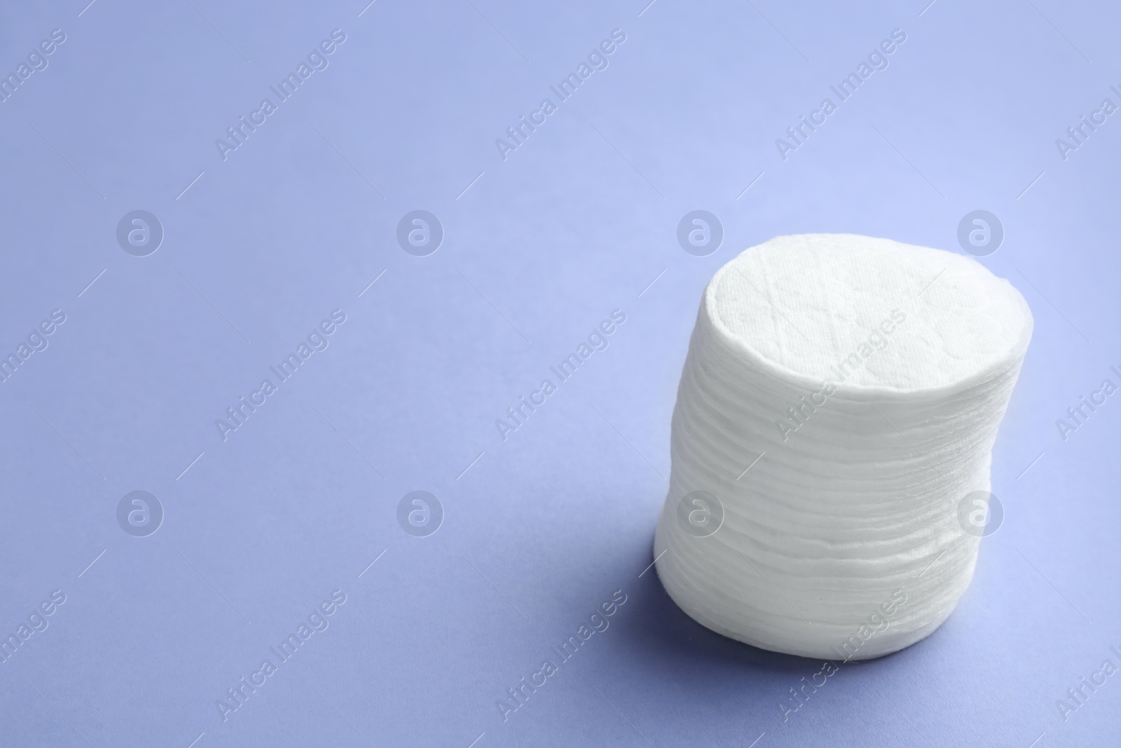 Photo of Stack of cotton pads on color background. Space for text