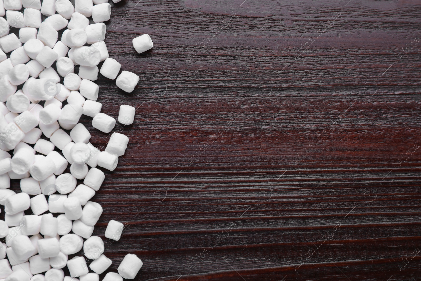 Photo of Delicious marshmallows on wooden table, flat lay. Space for text