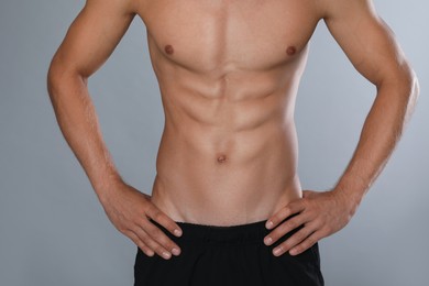 Photo of Shirtless man with slim body on grey background, closeup