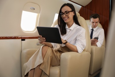 Photo of Businesswoman working on tablet in airplane during flight