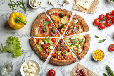 Photo of Flat lay composition with slices of different delicious pizzas on white marble table