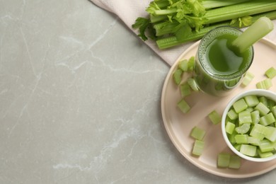 Glass of delicious celery juice and vegetables on grey table, flat lay. Space for text