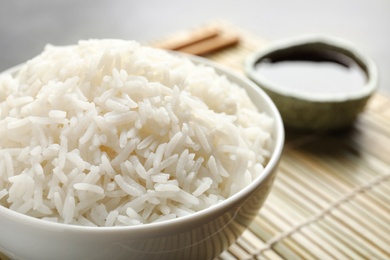 Bowl of tasty cooked rice served on table, closeup
