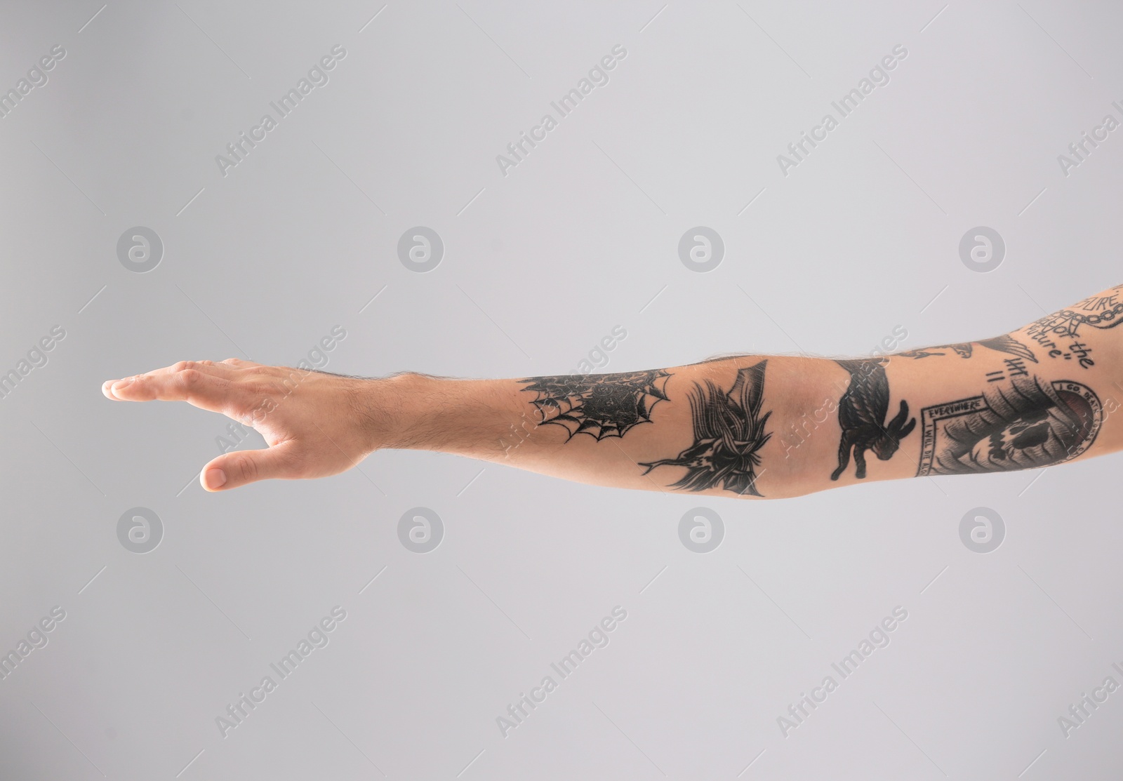 Photo of Man's arm with stylish tattoos on grey background