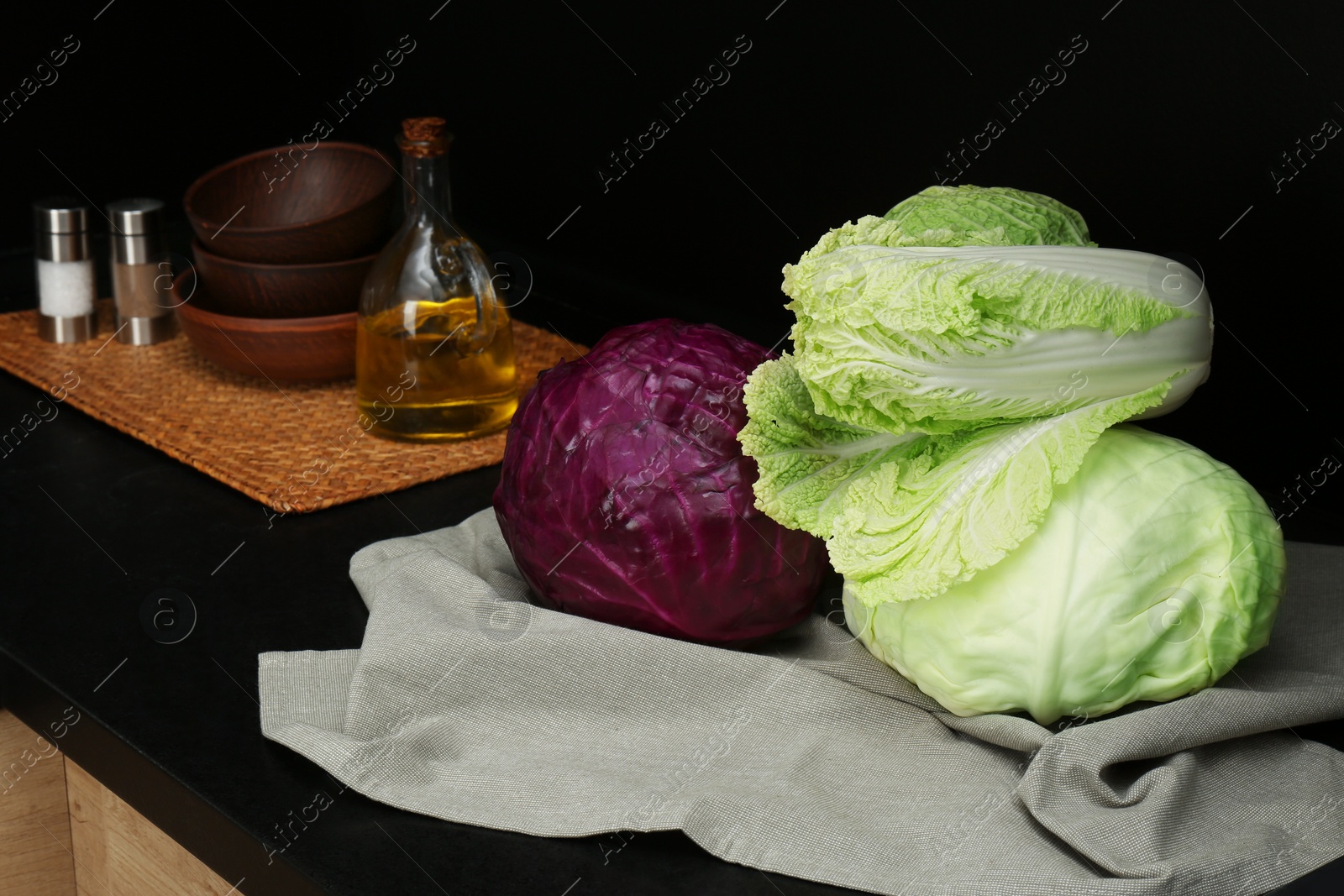 Photo of Different types of cabbage on countertop in kitchen, space for text