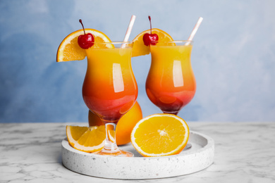 Photo of Fresh alcoholic Tequila Sunrise cocktails on marble table