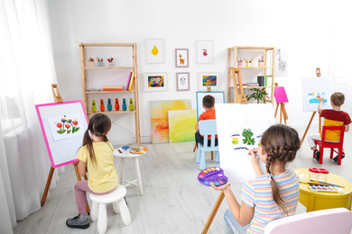 Photo of Cute little children painting during lesson in room