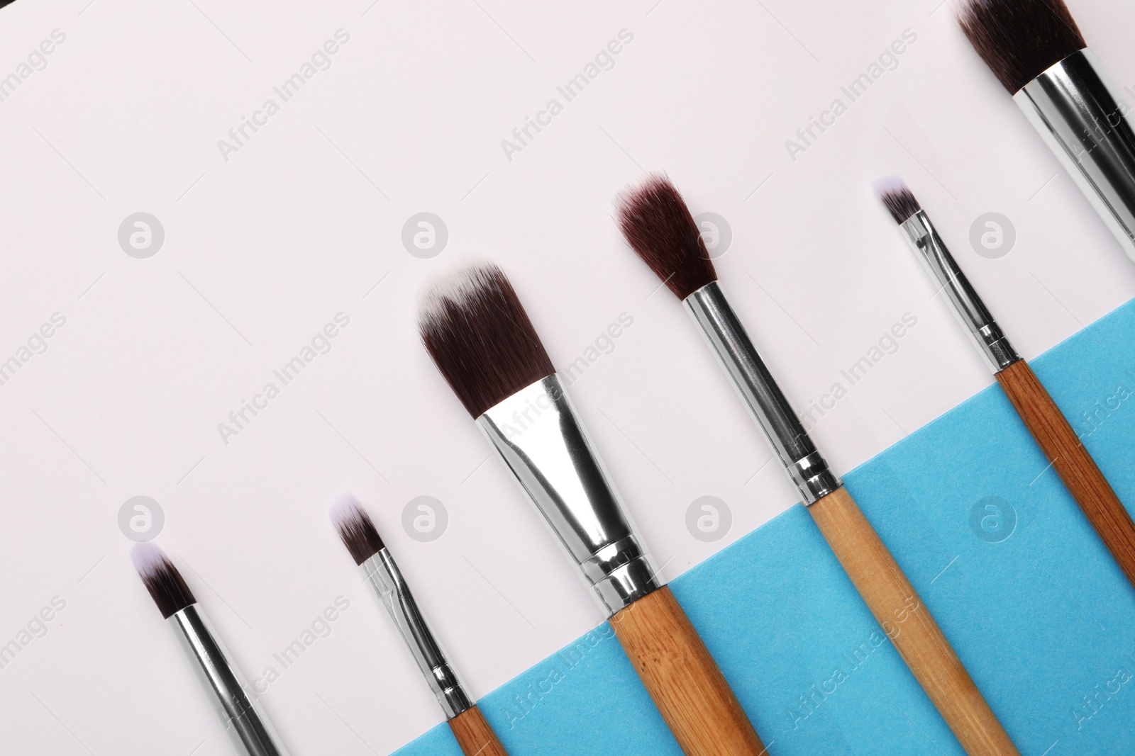 Photo of Different makeup brushes on color background, flat lay. Space for text