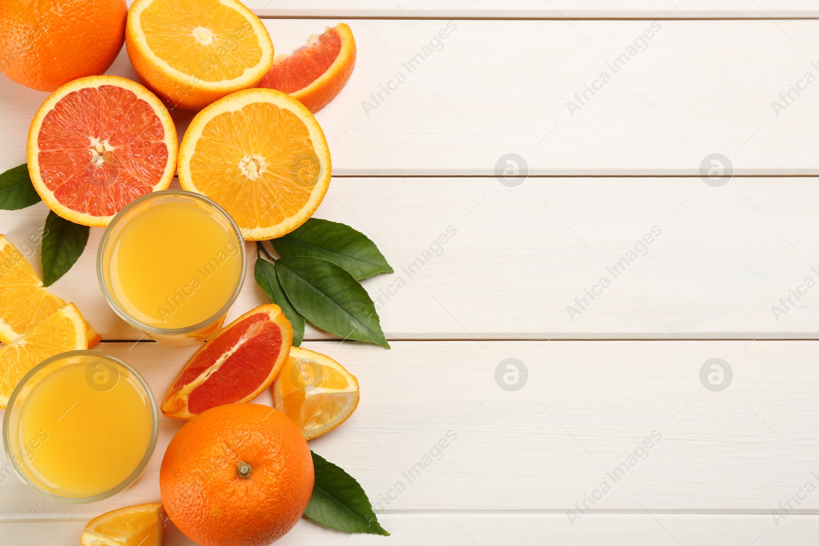 Photo of Delicious orange juice and fresh fruits on white wooden table, flat lay. Space for text