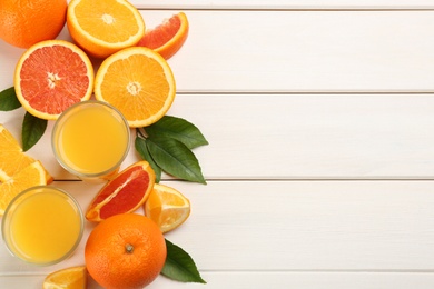 Photo of Delicious orange juice and fresh fruits on white wooden table, flat lay. Space for text