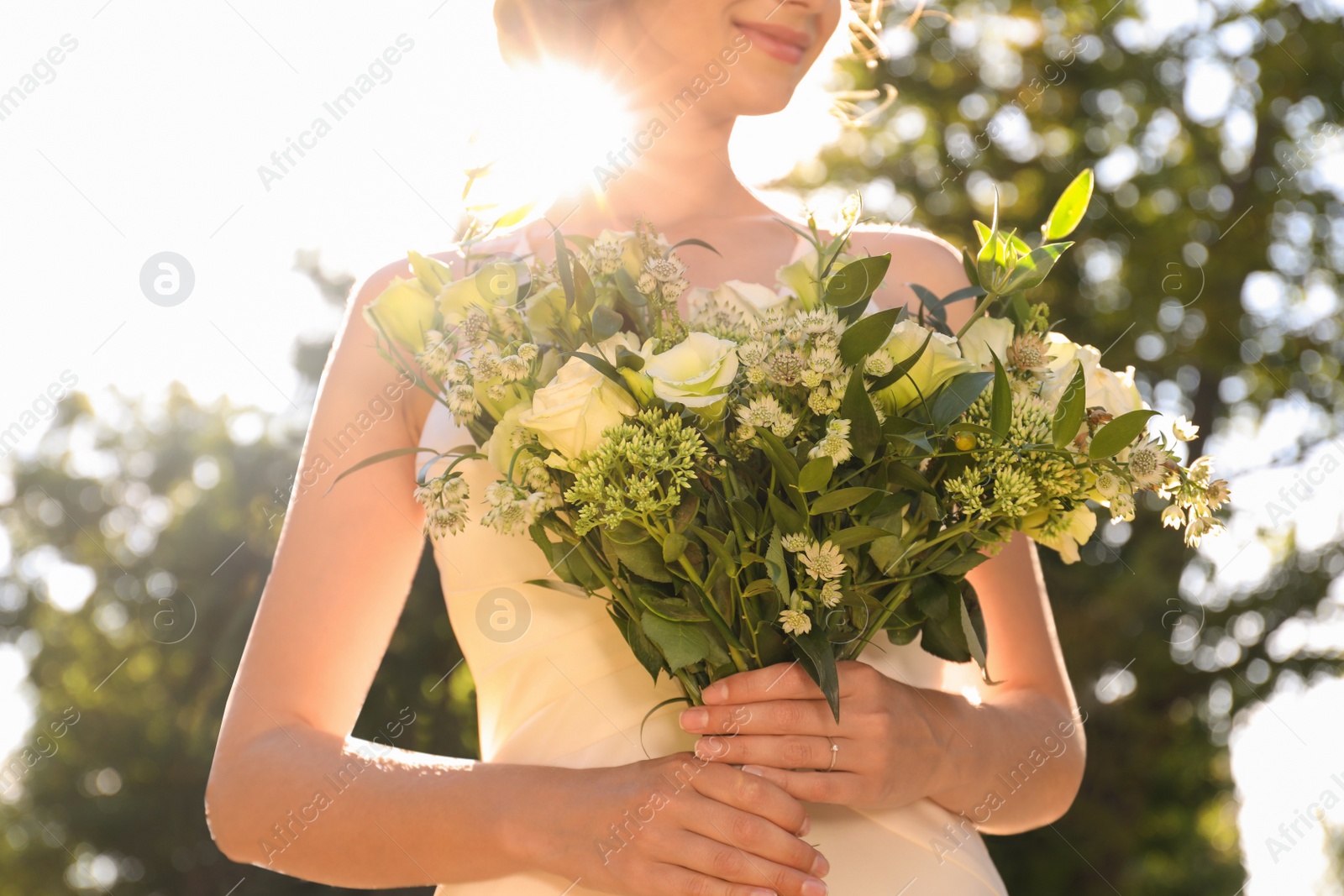 Photo of Bride in beautiful wedding dress with bouquet outdoors, closeup